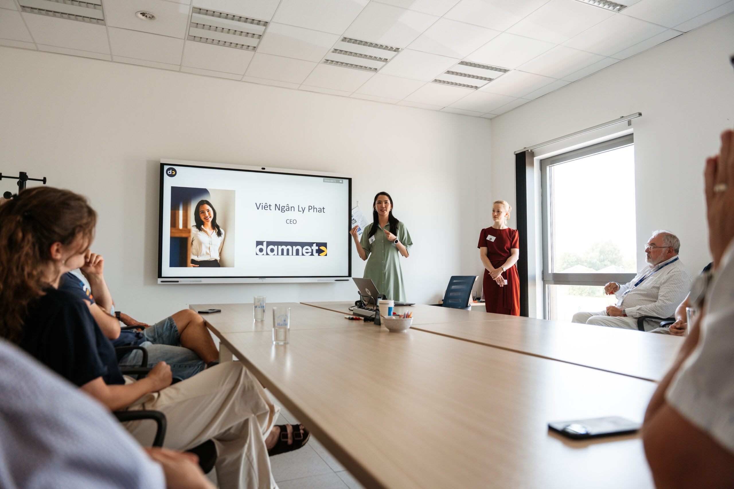 présentation d'un powerpoint avec oratrice debout devant écran